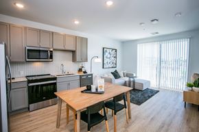 Las Vegas apartment for rent - A kitchen with a table and chairs in the foreground and a couch in the background.