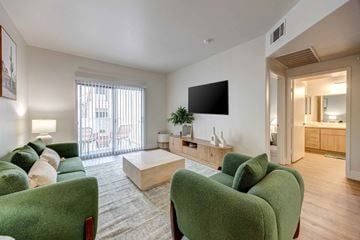 Las Vegas apartment for rent - A living room with green chairs and a flat screen TV.