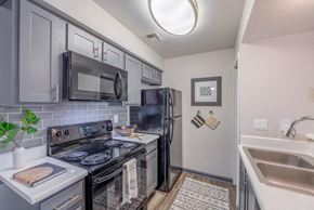 Las Vegas apartment for rent - Kitchen with a Black Refrigerator at 5400 Vistas Apartments, Las Vegas, NV, 89120