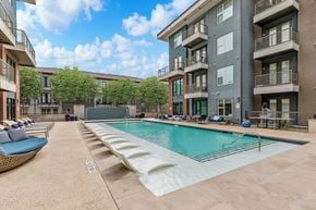 Dallas apartment for rent - A large swimming pool is surrounded by apartment buildings.