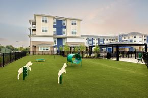 Waldorf apartment for rent - A playground with a slide and two animal figures on the grass in front of a building.