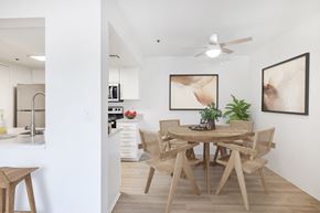 Ontario apartment for rent - a dining area with a wooden table and chairs and a kitchen in the background