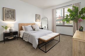 Sandy Springs apartment for rent - A bedroom with a bed, nightstand, and a plant.