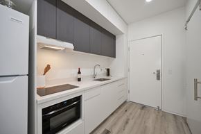 San Diego apartment for rent - a kitchen with white cabinets and a refrigerator and a sink