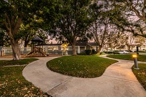Ontario apartment for rent - a walkway through a park with a playground and trees
