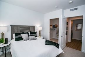 Las Vegas apartment for rent - A bedroom with a large bed and a nightstand with a lamp.