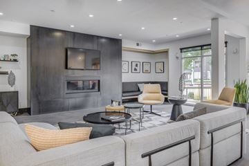 Salt Lake City apartment for rent - A modern living room with a grey sofa and a black fireplace.