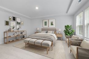 Rolesville apartment for rent - A bedroom with a bed, a chair, and a plant.