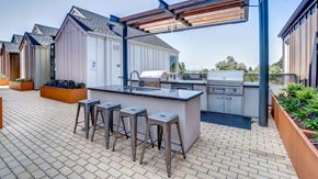 Berkeley apartment for rent - A patio with a bar and stools is surrounded by buildings.