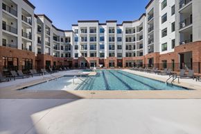 Apex apartment for rent - A large swimming pool in front of apartment buildings.