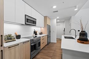 Sarasota apartment for rent - A modern kitchen with wooden cabinets and stainless steel appliances.
