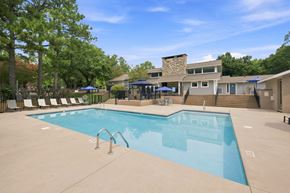 Chapel Hill apartment for rent - A large outdoor swimming pool with a stone building in the background.
