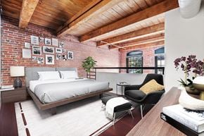 Philadelphia apartment for rent - loft bedroom with exposed brick and wood beam ceilings over looking the large living room with a ton of natural light.