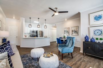 Frisco apartment for rent - A living room with a blue chair and a white ottoman.
