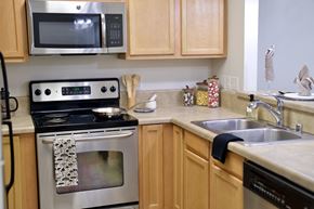 Tacoma apartment for rent - a kitchen with wooden cabinets and stainless steel appliances