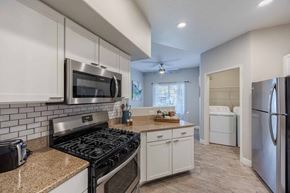 Las Vegas apartment for rent - A kitchen with a black stove top oven and white cabinets.