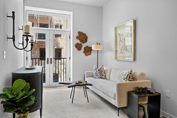 Simpsonville apartment for rent - A living room with a couch, a table, a plant, and a painting on the wall.