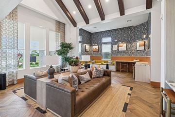 Saginaw apartment for rent - A living room with a brown leather couch and a wooden floor.
