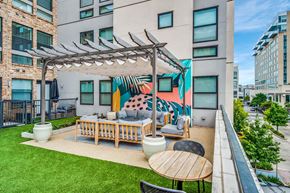 Houston apartment for rent - A patio with a table and chairs under a pergola.