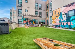 Houston apartment for rent - A backyard with a wooden deck and a mural on the wall.