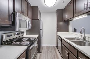 San Diego apartment for rent - A modern kitchen with dark brown cabinets and stainless steel appliances.