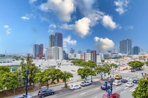 San Diego apartment for rent - A city street with cars and buildings in the background.