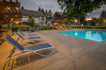 Swimming pool with lounge chairs and wooden pergola