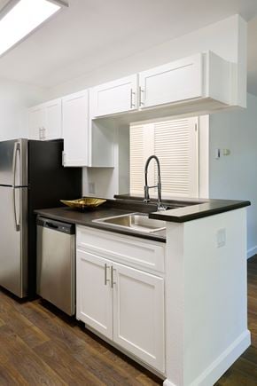 Morgan Hill apartment for rent - A kitchen with white cabinets and a black fridge.