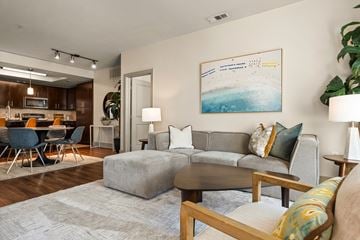 Anaheim apartment for rent - A living room with a grey couch, a coffee table, and a painting on the wall.