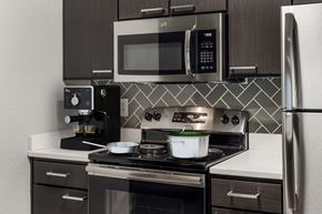 Orlando apartment for rent - A modern kitchen with a stove, microwave, and refrigerator.