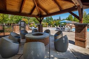 Tualatin apartment for rent - A group of grey chairs are arranged under a wooden roof.
