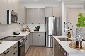 Gilbert apartment for rent - A modern kitchen with a stainless steel refrigerator and wooden floors.