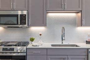 Gilbert apartment for rent - a kitchen with white cabinets and a sink and a microwave