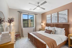 Chandler apartment for rent - A bedroom with a large bed and a view of a building outside the window.