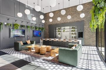 Chandler apartment for rent - A modern living room with a green couch and a TV on the wall.