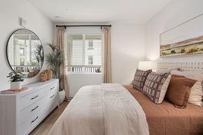 Fontana apartment for rent - A bedroom with a large bed and a mirror on the wall.