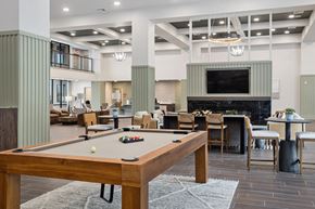 Goodyear apartment for rent - A pool table is in the middle of a room with a fireplace and a television.
