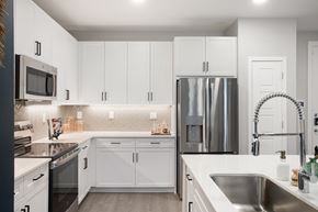 Goodyear apartment for rent - A modern kitchen with white cabinets and stainless steel appliances.