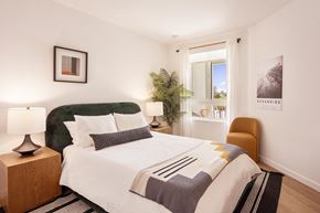Oceanside apartment for rent - a bedroom with a large bed and a window