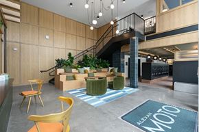 Raleigh apartment for rent - A modern office space with a staircase, chairs, and a green rug.