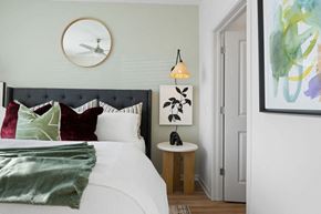 Raleigh apartment for rent - A bedroom with a white bed and a green blanket.