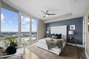 Charlotte apartment for rent - a bedroom with a large window and a bed and a ceiling fan
