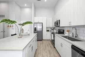 Charlotte apartment for rent - A modern kitchen with white cabinets and a marble countertop.