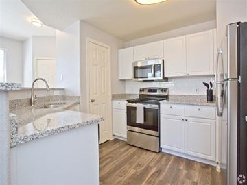 Prescott apartment for rent - A kitchen with white cabinets and a granite countertop.