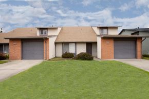 Marina apartment for rent - a house with two garages and a green lawn