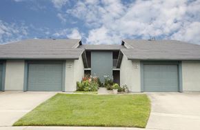 Marina apartment for rent - a house with three garages and a grassy area in front of it