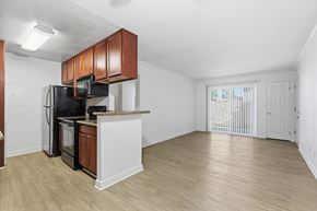 La Mesa apartment for rent - A modern kitchen with a black fridge and microwave, and brown cabinets.