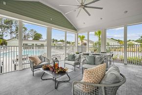 Myrtle Beach apartment for rent - a covered patio with furniture and a pool in the background