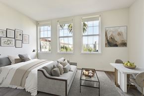 San Francisco apartment for rent - A bedroom with a bed, a table, and a painting on the wall.