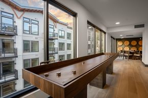 Woodinville apartment for rent - A shiny pool table is in the middle of a room with a balcony outside.